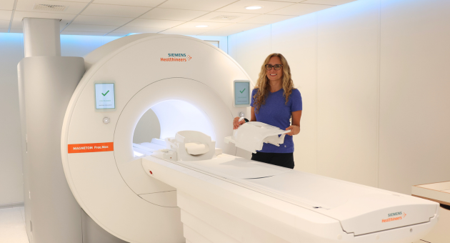 Michelle Cress, medical radiation technologist, standing beside the Magnetom Free.Max 0.55T MRI.
