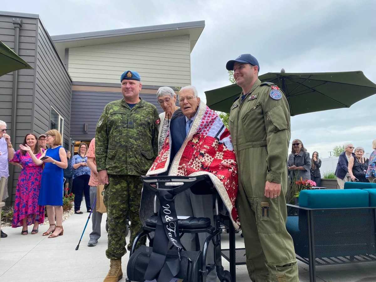 Richard Earl, 100, poses with current members of the 435 Transport and Rescue Squadron -- the same unit he was a member of during the Second World War.