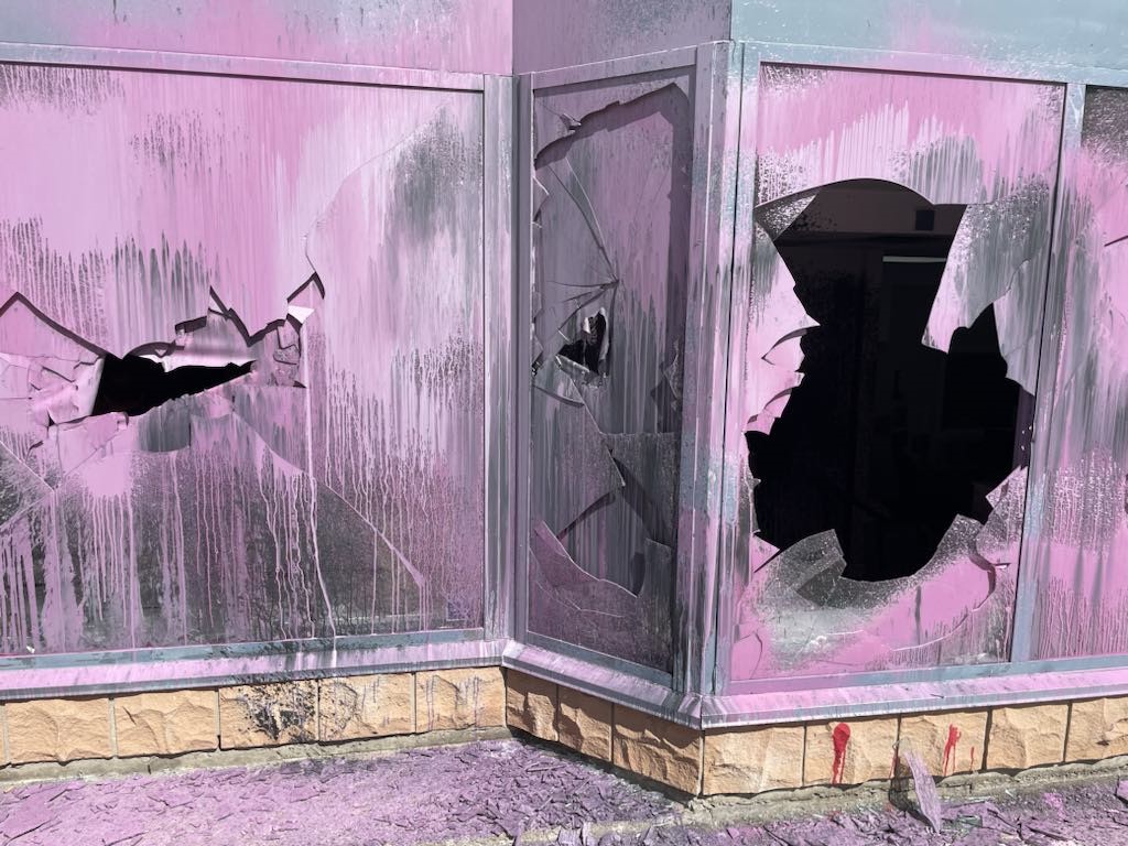 Smashed windows, spray painted pink.