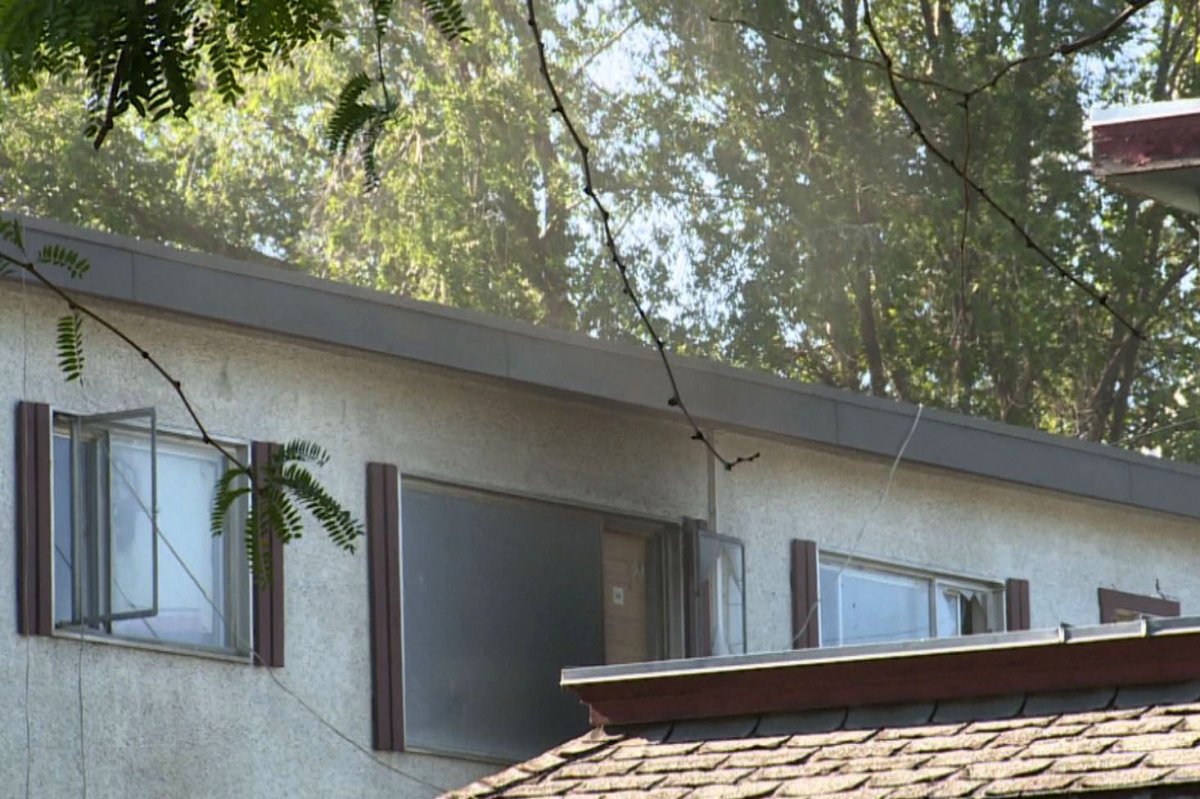 Smoke drifts from an apartment window that was blackened by fire in Kelowna, B.C., on Friday, July 12, 2024.