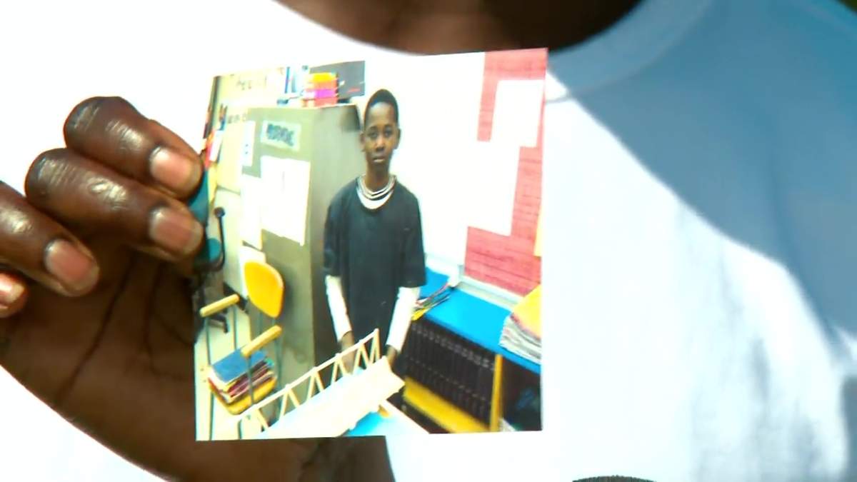 The grieving mother of Matt Arkangelo holds a photo of her son as a child at a news conference in Edmonton, Alta. on Tuesday, July 16, 2024.