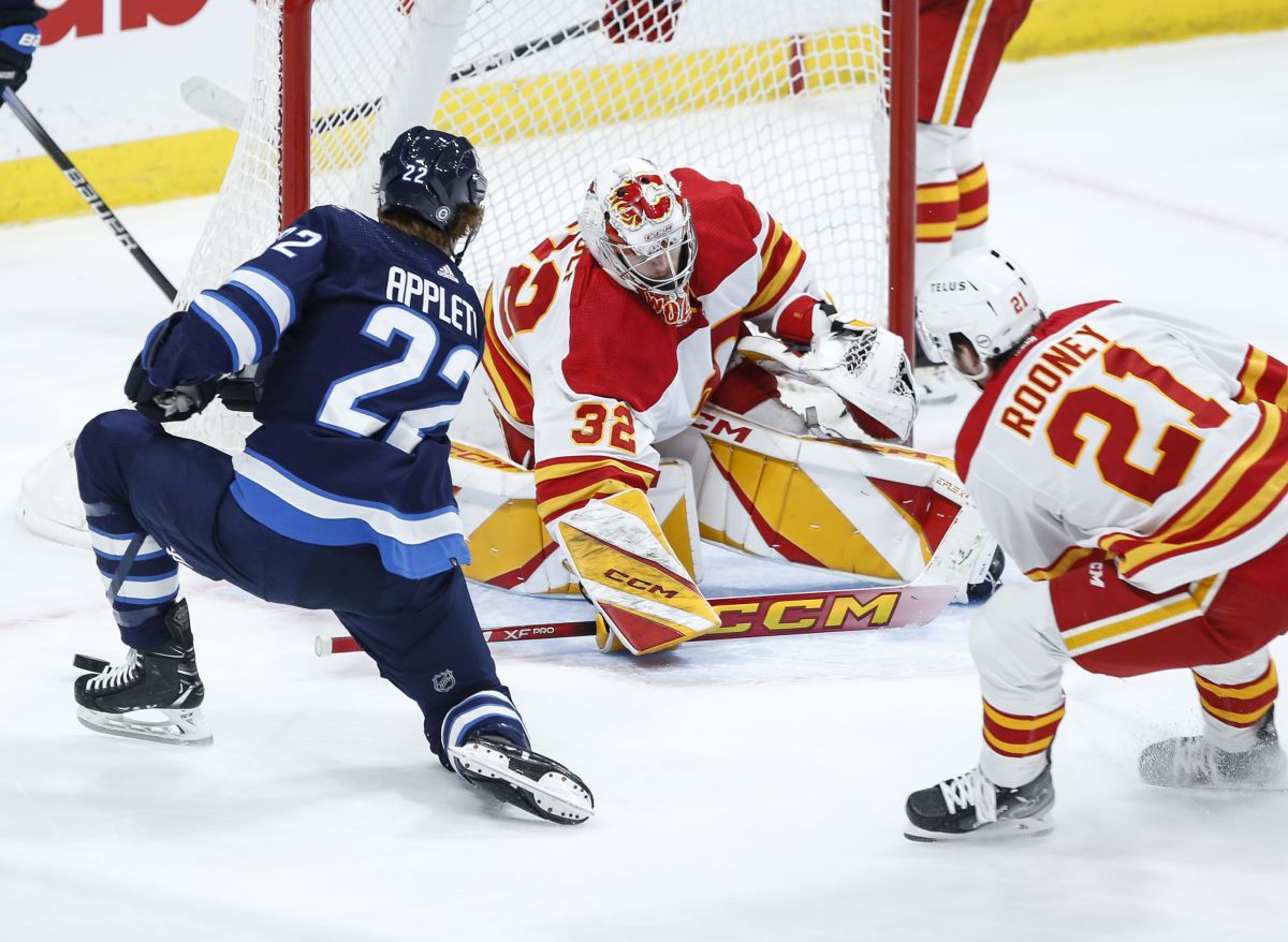 Calgary Flames goaltender Dustin Wolf (32) saves the shot from Winnipeg Jets' Mason Appleton (22) during third period NHL action in Winnipeg on Thursday, April 4, 2024.