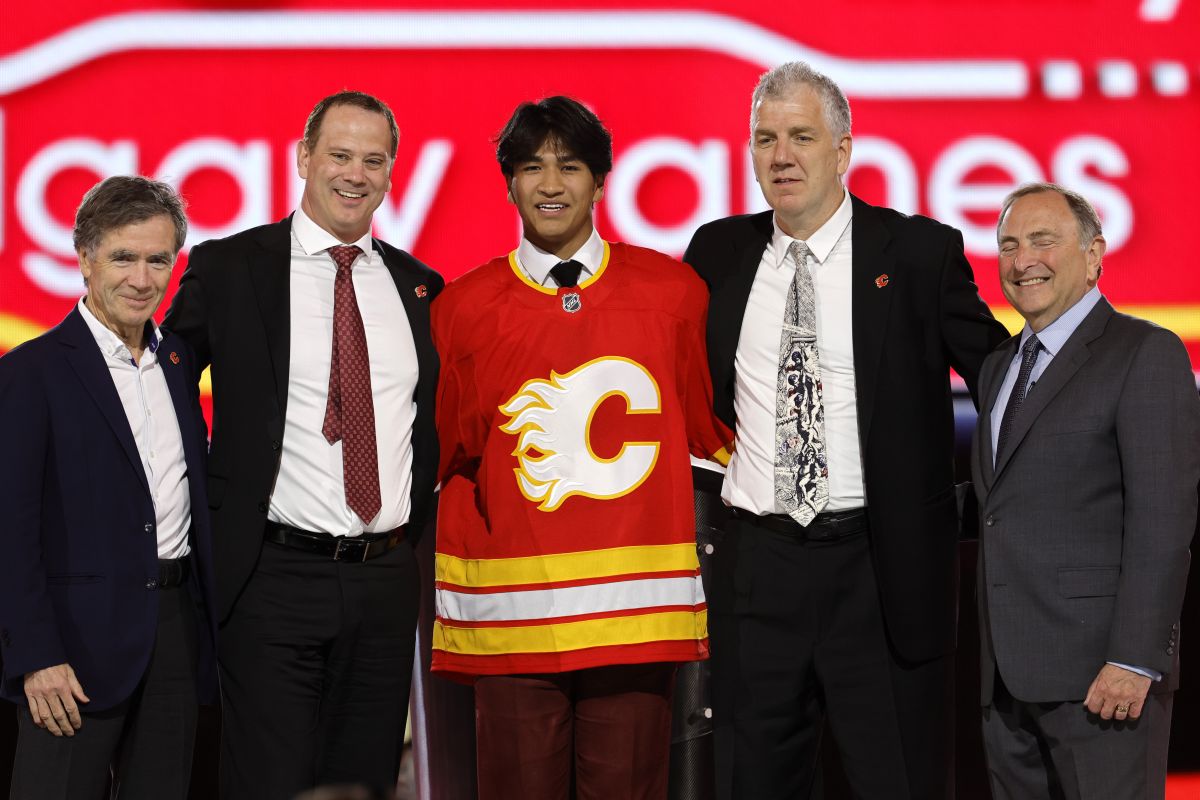 Zayne Parekh, centre, poses after being selected by the Calgary Flames during the first round of the NHL hockey draft Friday, June 28, 2024, in Las Vegas.