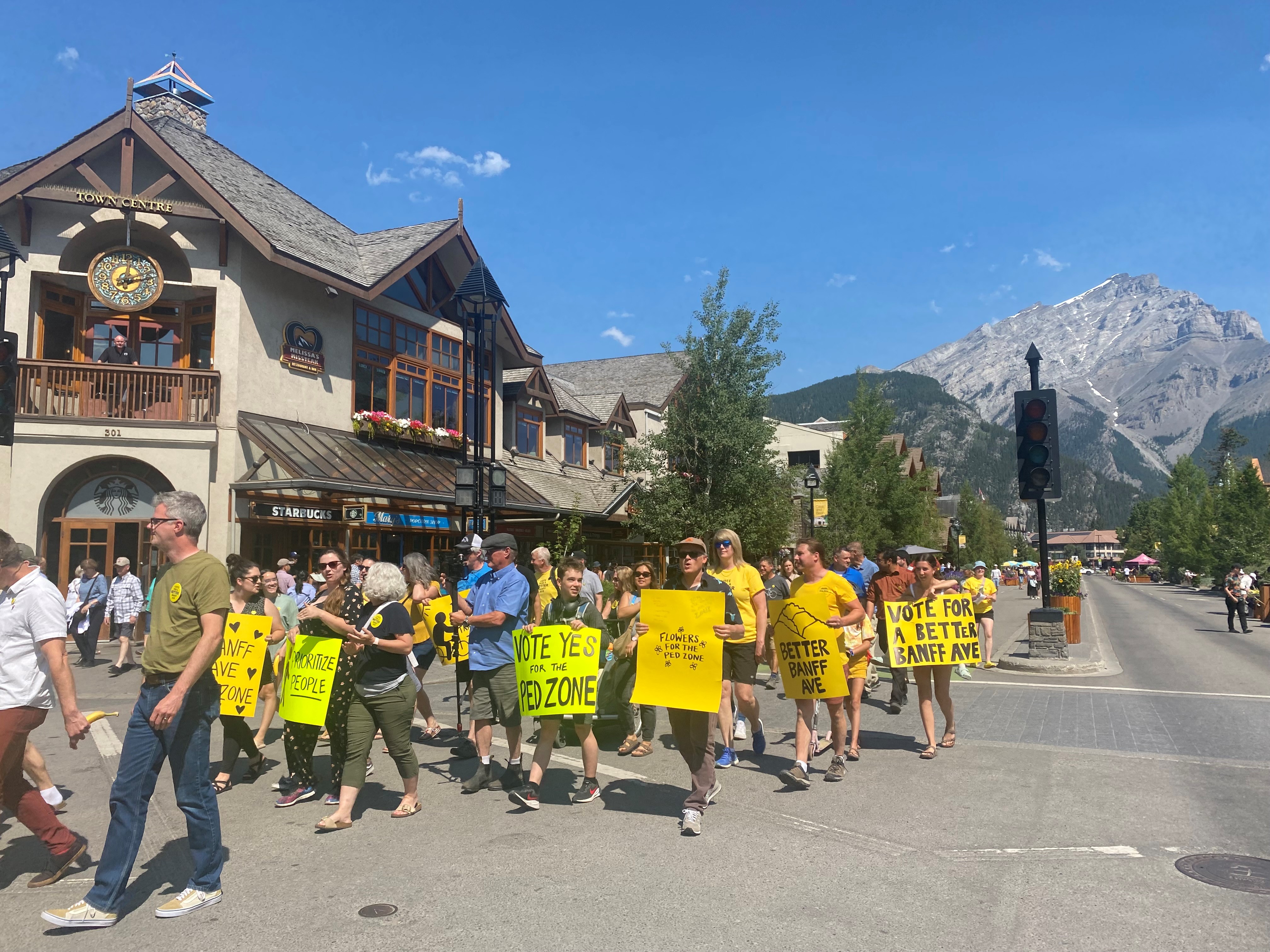 Група жители на Banff са настроени за Banff Avenue насърчавайки