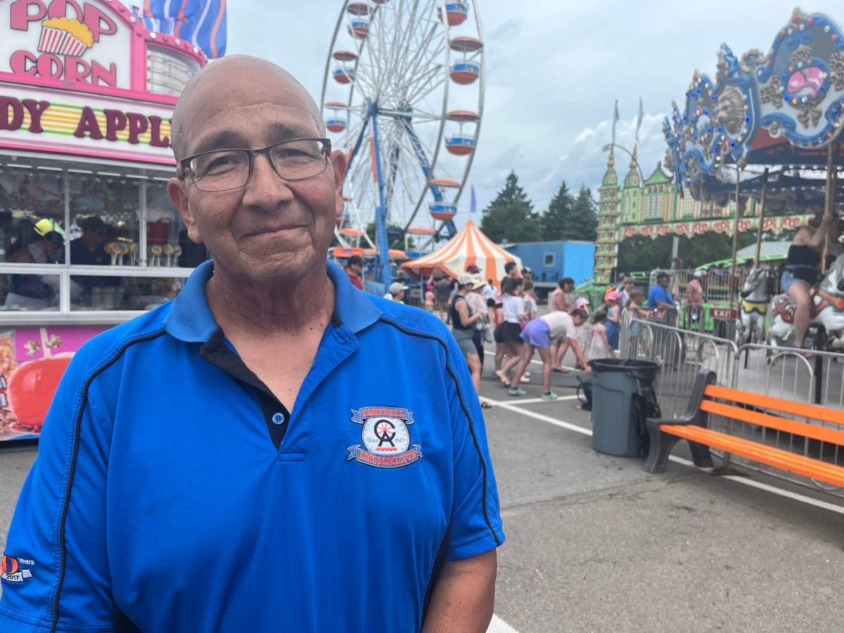 Beau Miller stands among the rides at the festival
