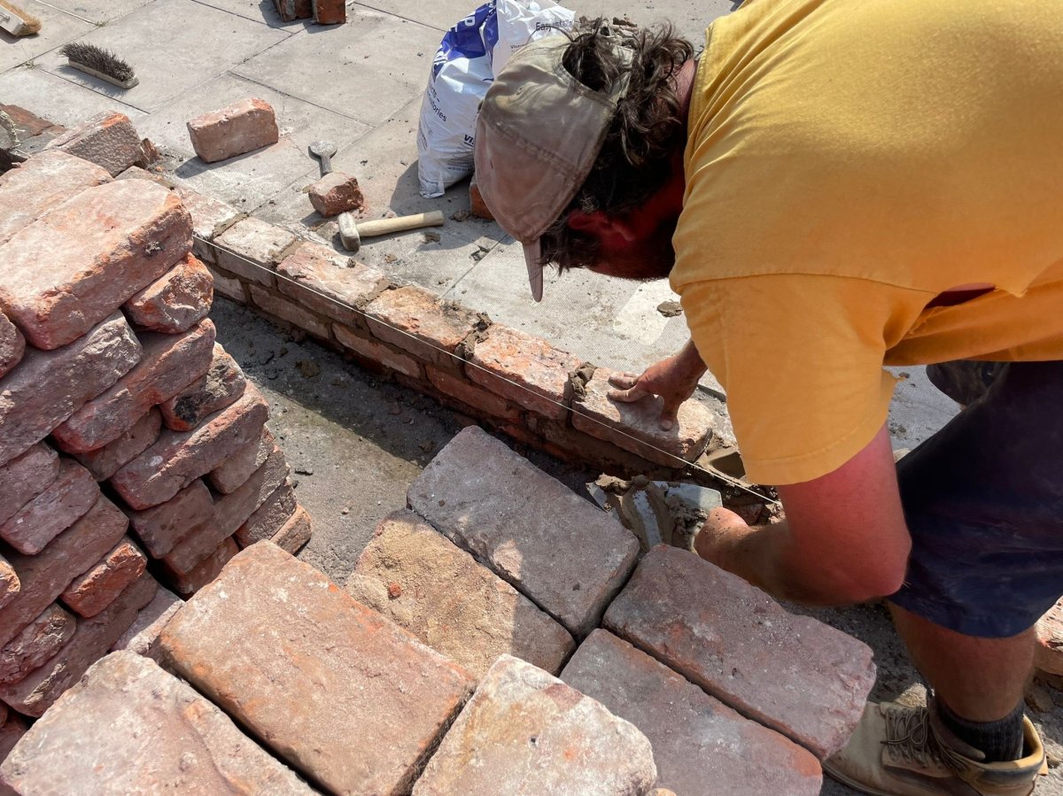 An individual helps repair a broken garden wall after Tuesday night's protest in Southport.