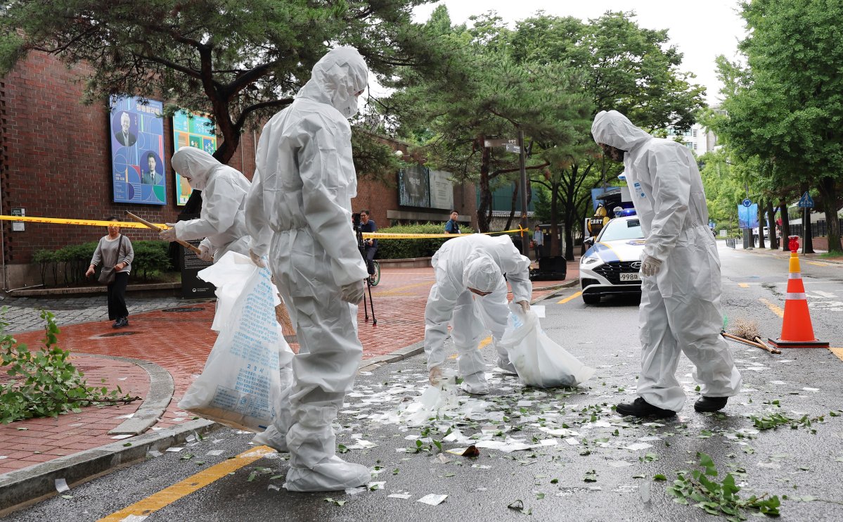 Officers wearing protective gear collect the trash from a balloon presumably sent by North Korea, Wednesday, July 24, 2024, in Seoul, South Korea