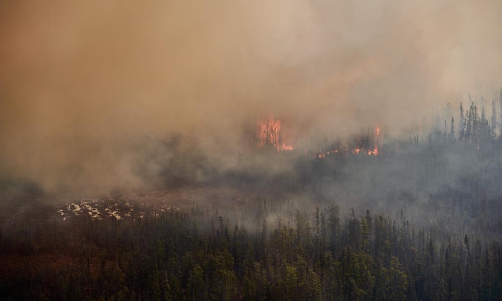 A wildfire burns in northern Manitoba near Flin Flon, as seen from a helicopter surveying the situation, May 14, 2024. THE CANADIAN PRESS/David Lipnowski.