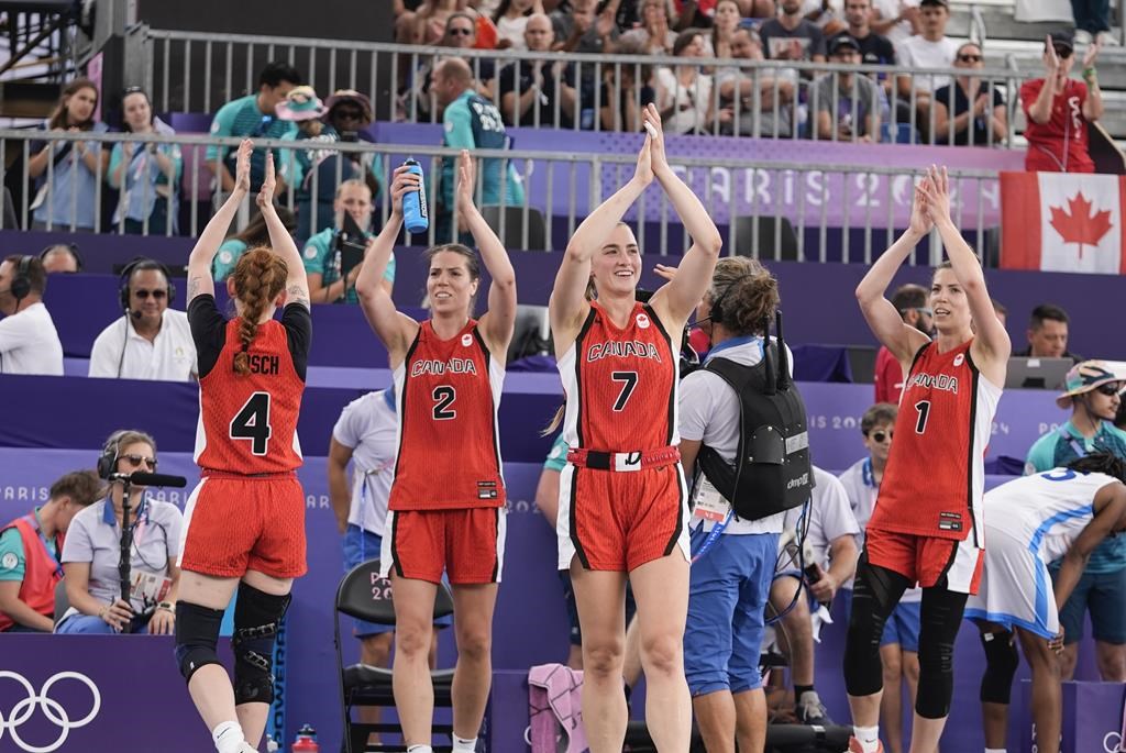 Canada's Kacie Bosch (4), Katherine Plouffe (2), Paige Crozon (7) and Michelle Plouffe (1) celebrate after a women's 3x3 basketball pool round match against against Azerbaijan during the 2024 Summer Olympics, Saturday, Aug. 3, 2024, in Paris, France. Canada won 21-19. THE CANADIAN PRESS/AP-Frank Franklin II.