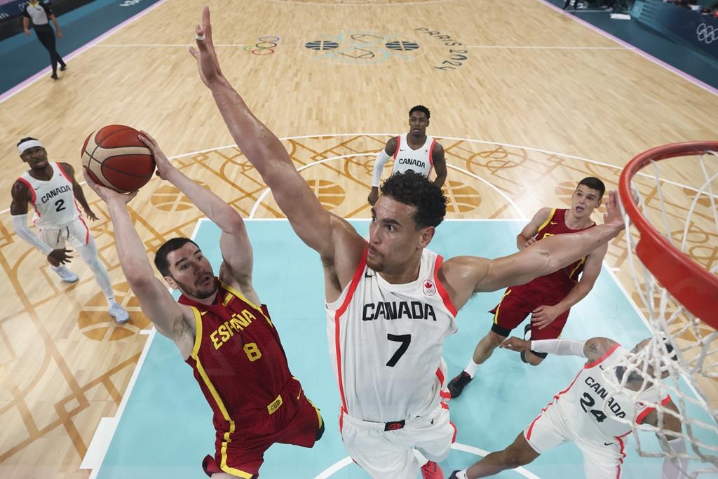 Darío Brizuela, of Spain, shoots over Dwight Powell, of Canada, in a men's basketball game at the 2024 Summer Olympics, Friday, Aug. 2, 2024, in Villeneuve-d'Ascq, France. (Gregory Shamus/Pool Photo via AP).
