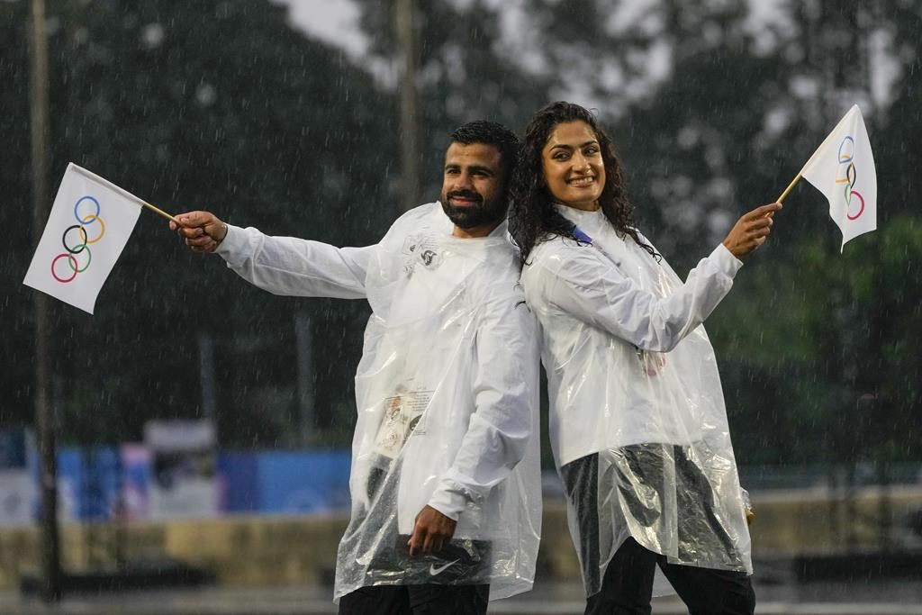 Judo competitors Mohammad Rashnonezhad, left, and Nigara Shaheen, both of the Olympic refugee team, pose for a photograph in Paris, France, during the opening ceremony of the 2024 Summer Olympics, Friday, July 26, 2024. THE CANADIAN PRESS/AP-Andy Wong.