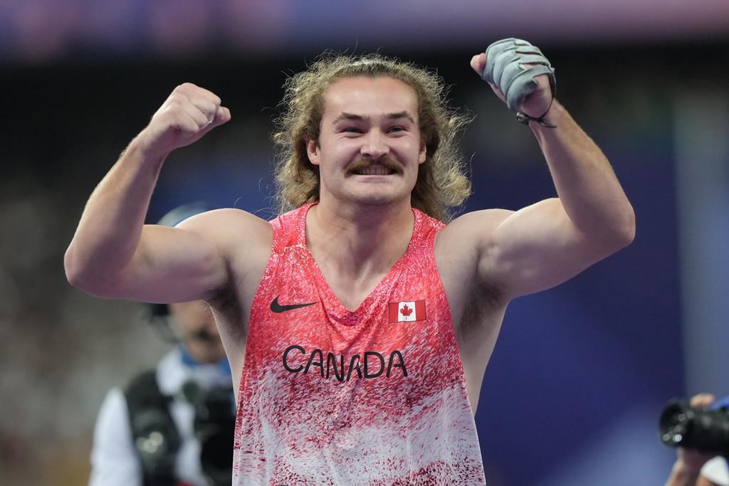 Ethan Katzberg, of Nanaimo, B.C., celebrates after winning gold in the men's hammer throw event at the 2024 Summer Olympics, Sunday, Aug. 4, 2024, in Saint-Denis, France. THE CANADIAN PRESS/Nathan Denette.