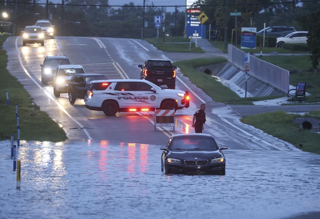 A BMW sedan is stalled in high water along southbound US Alt 19 in Tarpon Springs, Fla., Monday morning, Aug 5, 2024, as Hurricane Debby passes the Tampa Bay area offshore. (Douglas R. Clifford/Tampa Bay Times via AP)