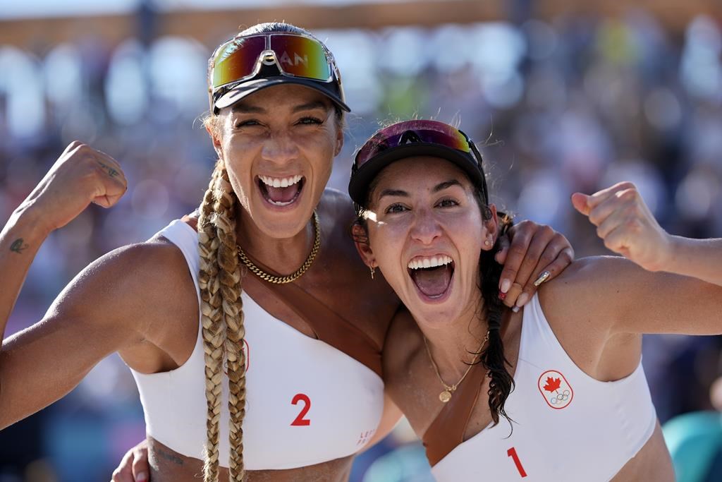 Canada's Brandie Wilkerson, left, and Melissa Humana-Paredes give a celebratory pose after defeating the United States in a beach volleyball match at the 2024 Summer Olympics, Monday, Aug. 5, 2024, in Paris, France. THE CANADIAN PRESS/AP-Robert F. Bukaty.