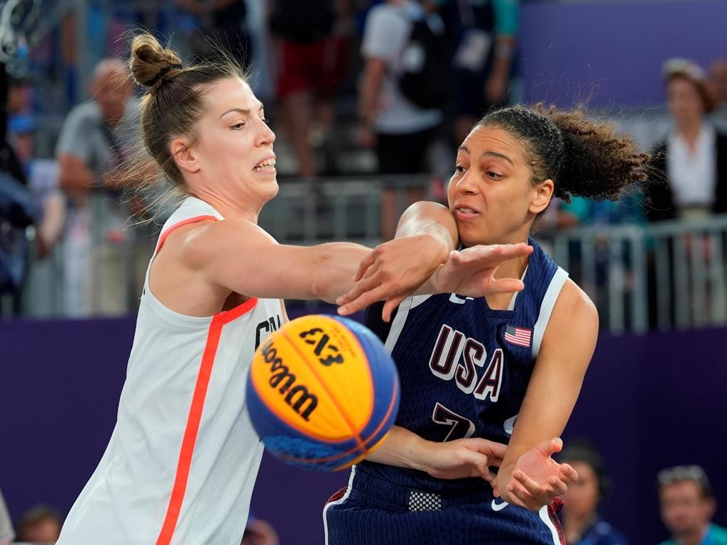 Canada's Michelle Plouffe (left) and United States Cierra Burdick (7) battle for the ball during the women's 3 X 3 basketball bronze medal game at the Summer Olympics in Paris on Monday, Aug.5, 2024. THE CANADIAN PRESS/Adrian Wyld.