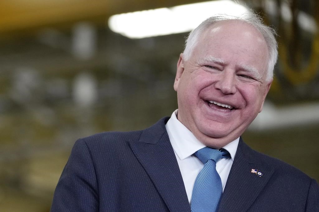 FILE – Minnesota Gov. Tim Walz, right, laughs as he stands with Fridley, Minn., Mayor Scott Lund during a visit to the Cummins Power Generation Facility in Fridley, Minn., Monday, April 3, 2023. (AP Photo/Carolyn Kaster, File)