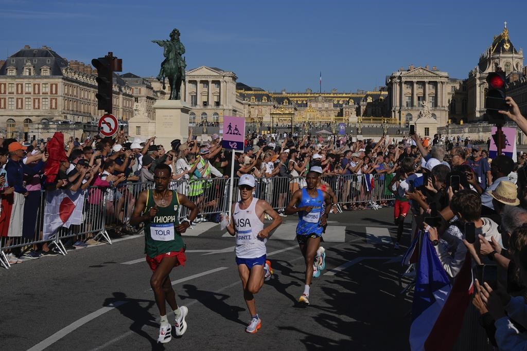 Competitors run past spectators near the Palace of Versailles during the men's marathon at the 2024 Summer Olympics, Saturday, Aug. 10, 2024, in Versailles, France. THE CANADIAN PRESS/AP-POOL, Rebecca Blackwell.