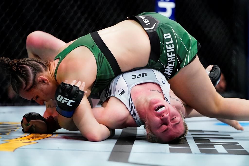 England's Molly McCann, right, attempts to break the hold of Erin Blanchfield, left, during the first round of a women's flyweight bout at the UFC 281 mixed martial arts event Saturday, Nov. 12, 2022.