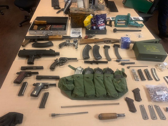 Police say they found a large number of firearms and ammunition, including a loaded AK-47 and magazines, carelessly stored.