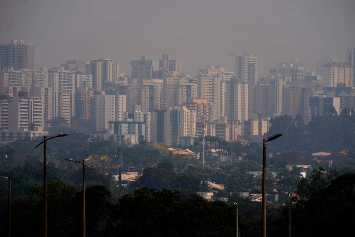 Smoke stemming from nearby wildfires and dry weather covers the Aguas Claras neighborhood of Brasilia, Brazil, Sunday, Aug. 25, 2024. (AP Photo/Eraldo Peres)