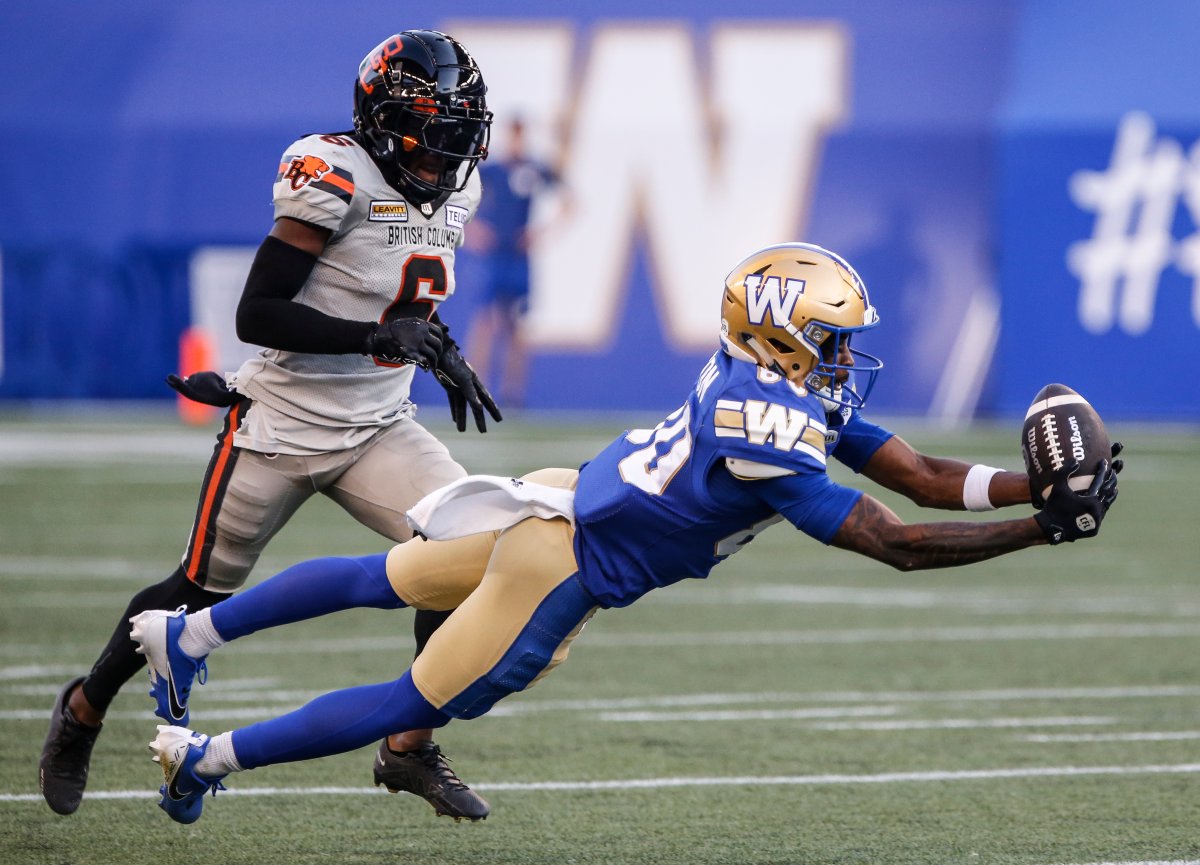 Winnipeg Blue Bombers' Ontaria Wilson (80) catches the pass as B.C. Lions' T.J. Lee (6) defends during first half CFL action in Winnipeg Thursday, August 1, 2024.    THE CANADIAN PRESS/John Woods.
