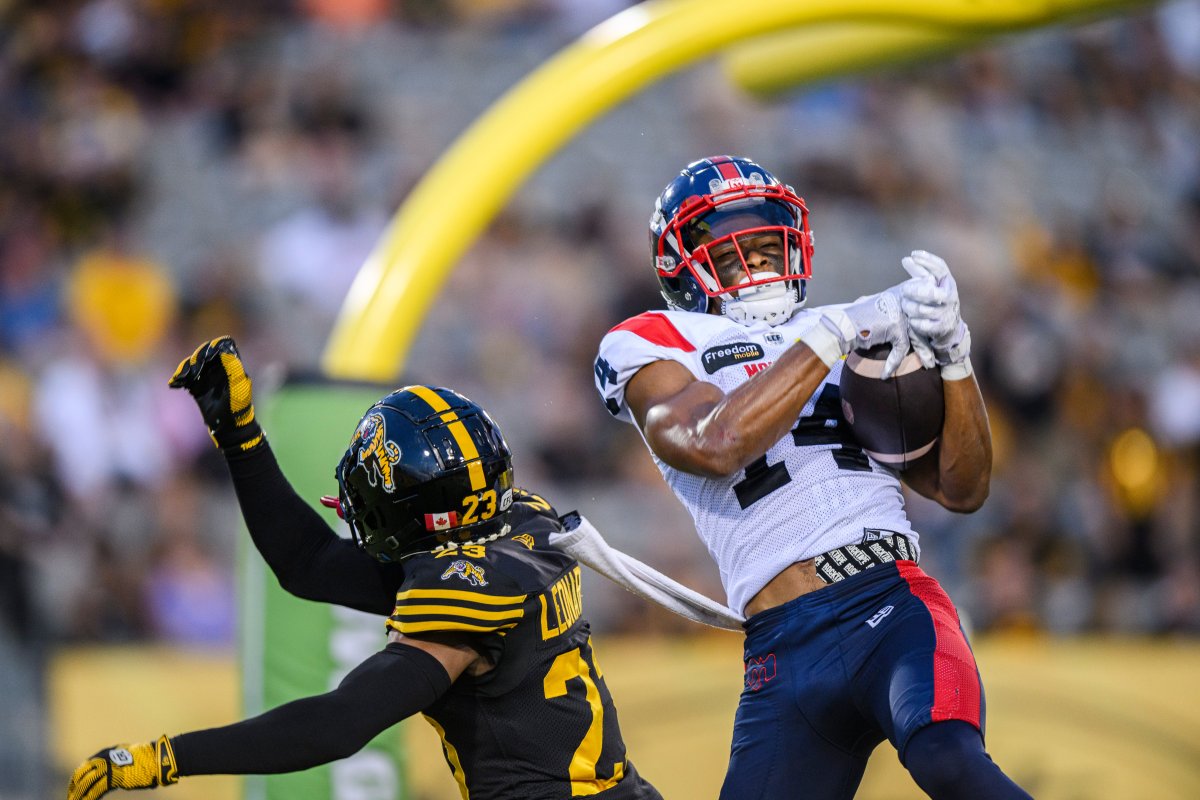 Montreal Alouettes wide receiver Charleston Rambo (14) catches a pass to score a touchdown while Hamilton Tiger-Cats defensive back Richard Leonard (23) defends during first half CFL football action, in Hamilton, Ont., on Friday, August 2, 2024. 