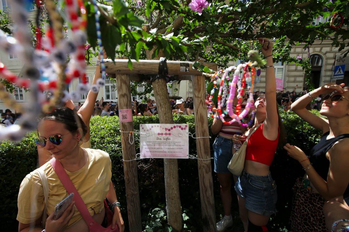 Swifties fix bracelets on a tree in the city centre in Vienna on Thursday, Aug. 8, 2024.