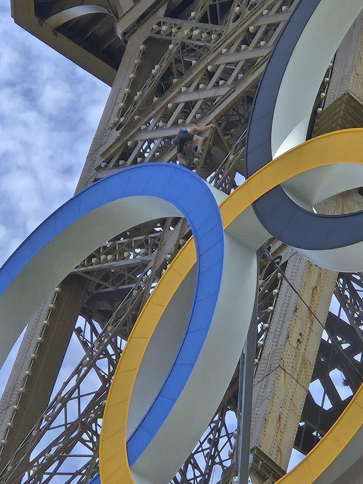 In this photo provided by Nicky Worlock, a man climbs the Eiffel Tower, during the 2024 Summer Olympics, Sunday, Aug. 11, 2024, in Paris France.