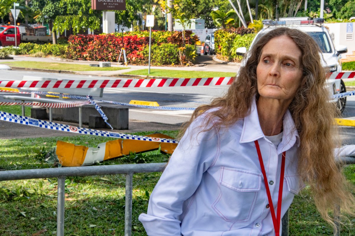 Witness Veronica Knight walks past a piece of helicopter wreckage in Cairns, Australia, following the crash of the aircraft, Monday, Aug. 12, 2024.