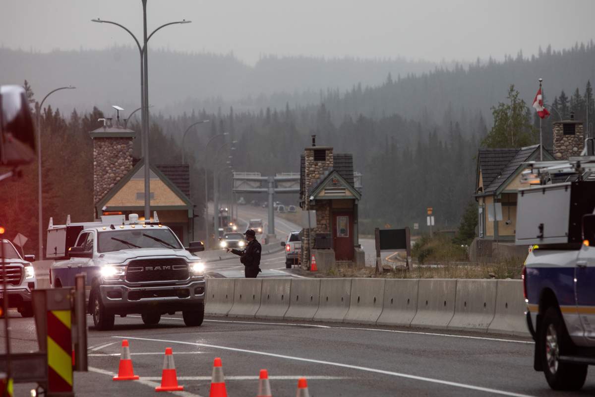 Police and Park rangers wait for residents at the park gates on the first day residents are able to visit their Jasper, Alberta, properties on Friday August 16, 2024. Wildfire caused evacuations and widespread damage in the National Park and Jasper townsite.