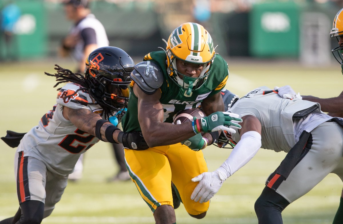 B.C. Lions ' Cristophe Beaulieu (29) and Garry Peters (1) tackle Edmonton Elks' Tevin Jones (84) during first half CFL action in Edmonton, Sunday, Aug. 11, 2024.