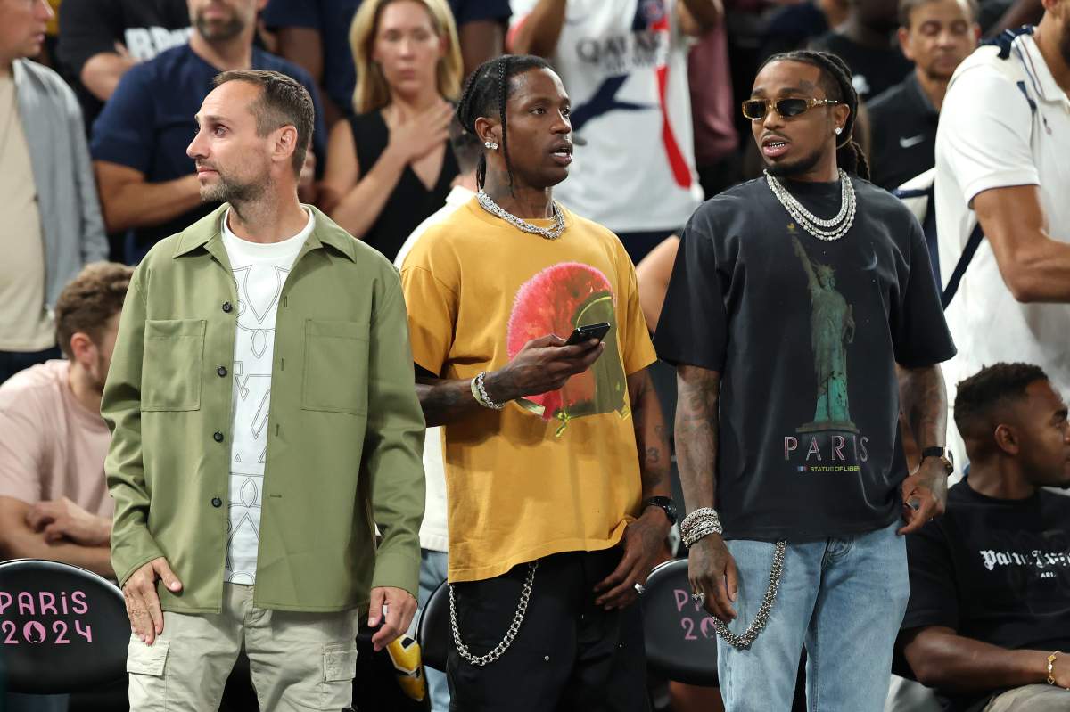 Michael Rubin, Travis Scott and Quavo standing courtside at a basketball game.