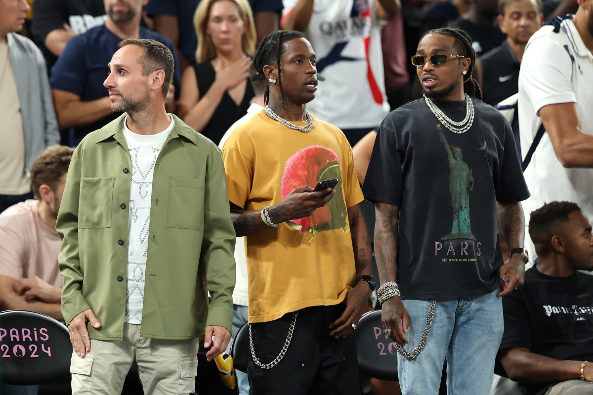 Michael Rubin, Travis Scott and Quavo standing courtside at a basketball game.