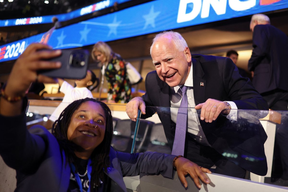 Minnesota Governor and 2024 Democratic vice presidential candidate Tim Walz poses for pictures with an attendee on the first day of the Democratic National Convention (DNC) at the United Center in Chicago, Illinois, on August 19, 2024.