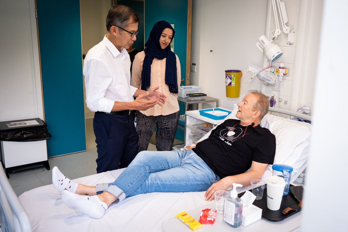 UCLH consultant medical oncologist Siow Ming Lee and Dr Sarah Benafif talking with patient Janusz Racz before receiving an injection of a BioNTech mRNA cancer immunotherapy.