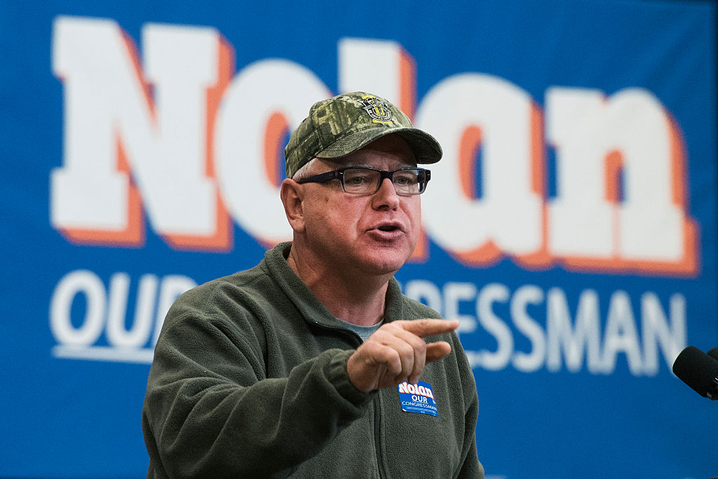 FILE - Tim Walz has a long history of wearing his camo hat. Here he is, in 2016, speaking to a crowd at the University of Minnesota Duluth.