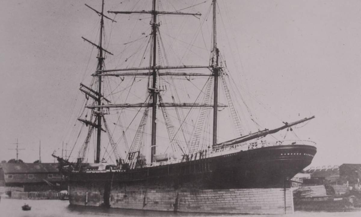 A black and while image of a large wooden ship with three masts