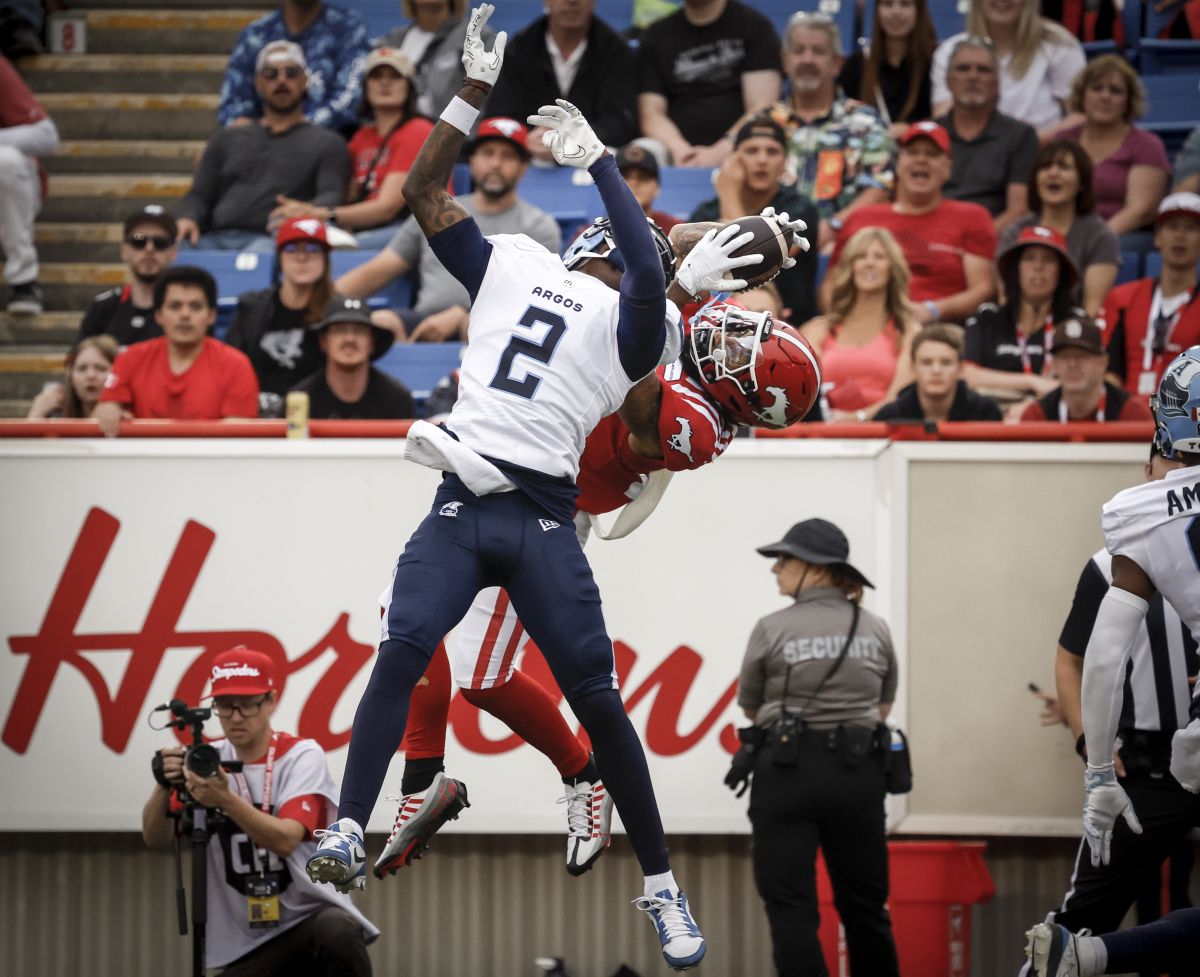 Toronto Argonauts' Tarvarus McFadden (2) tries block as touchdown catch by Calgary Stampeders' Cameron Echols-Luper (17) during second half CFL football action in Calgary, Alta., Sunday, Aug. 4, 2024.