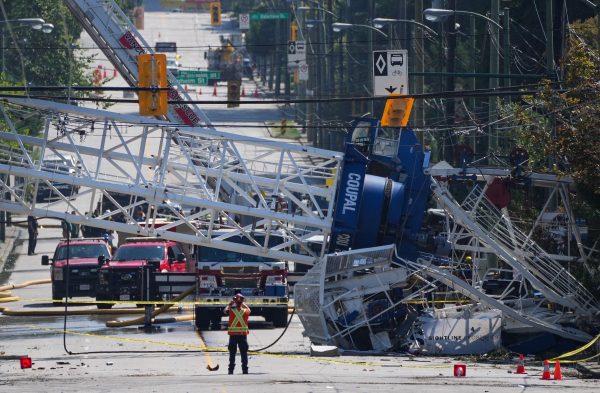 A crane that collapsed during a fire at an apartment building under construction lies across the road in Vancouver on Wednesday, August 7, 2024.