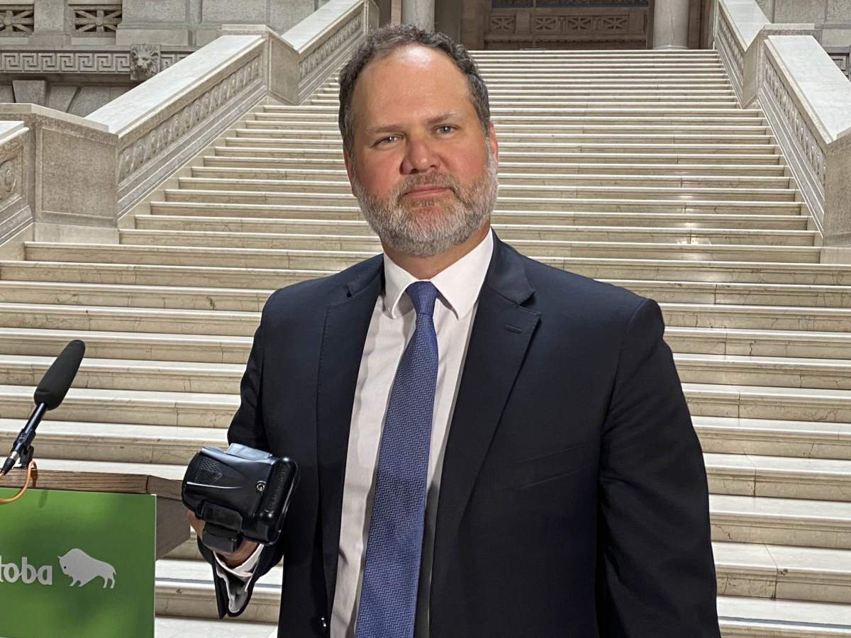 Justice minister Matt Wiebe displays an ankle monitor.