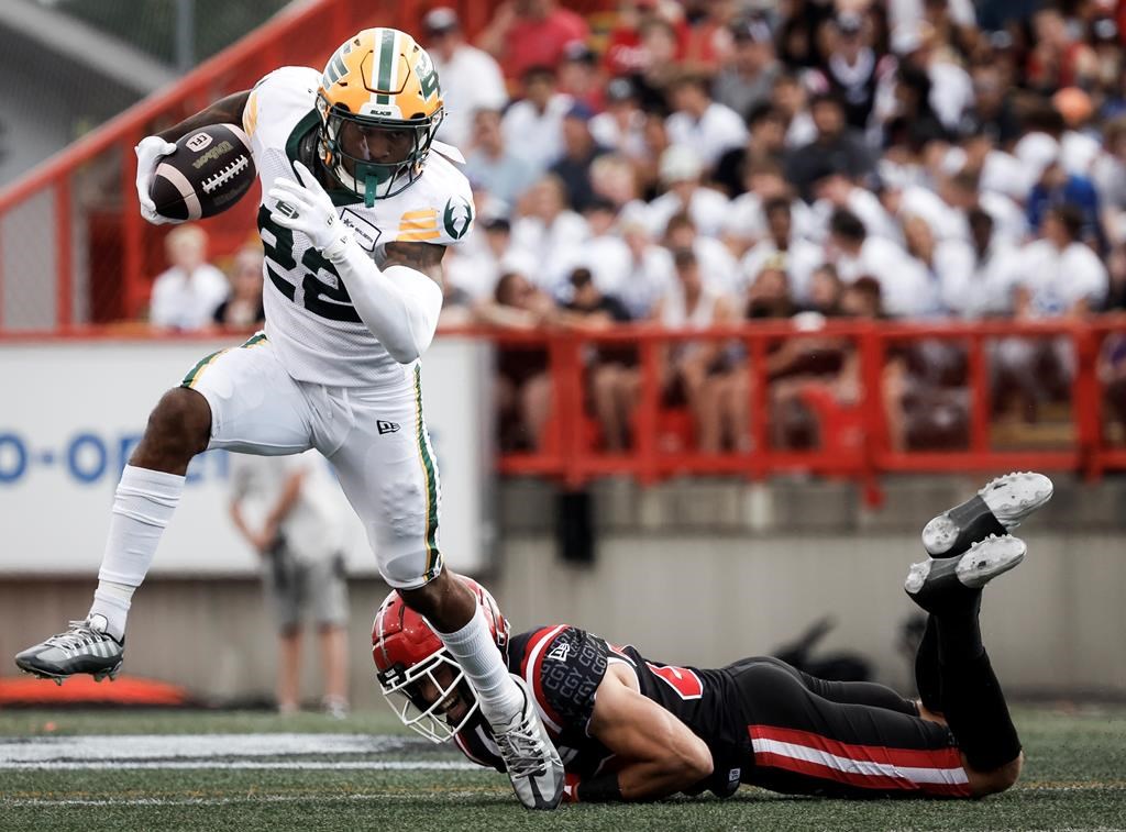 Edmonton Elks' Javon Leake (22) escapes a tackle by Calgary Stampeders' Ben Labrosse (29) during first half CFL football action in Calgary, Monday, Sept. 2, 2024.