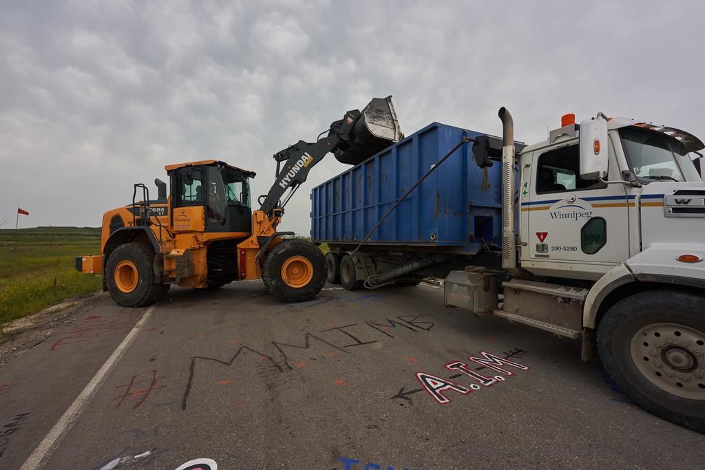 City of Winnipeg workers remove the blockade on the main road into the Brady Road landfill just outside of Winnipeg Tuesday July 18, 2023. 