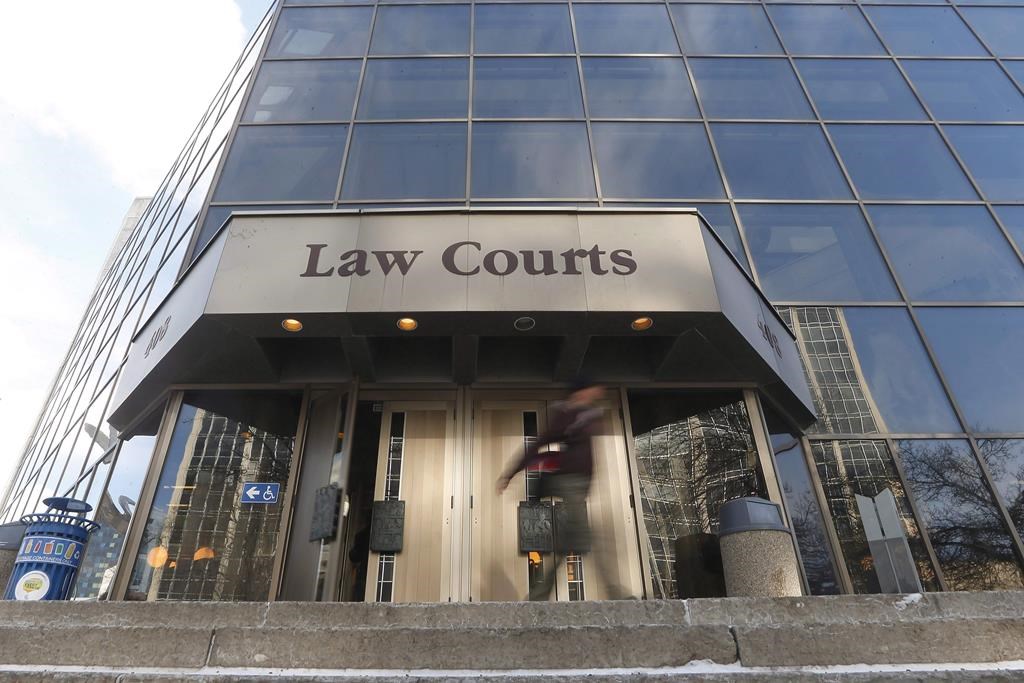 People enter the Law Courts in Winnipeg on Monday, Feb. 5, 2018. A judge has approved a settlement for three class-action lawsuits, worth $530 million, over child benefit payments that were clawed back by the Manitoba government.