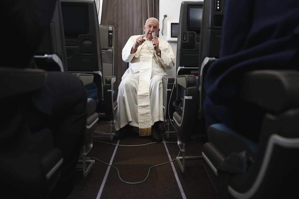 Pope Francis holds a news conference aboard the papal plane on his flight back after his 12-day journey across Southeast Asia and Oceania, Friday, Sept. 13, 2024.