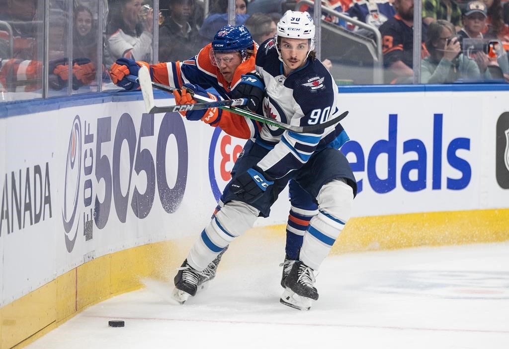 Winnipeg Jets' Nikita Chibrikov (90) checks Edmonton Oilers' James Hamblin (57) during first period NHL preseason action in Edmonton on Sunday September 24, 2023. The Winnipeg Jets have some huge holes to fill on both offence and defence this season. THE CANADIAN PRESS/Jason Franson.