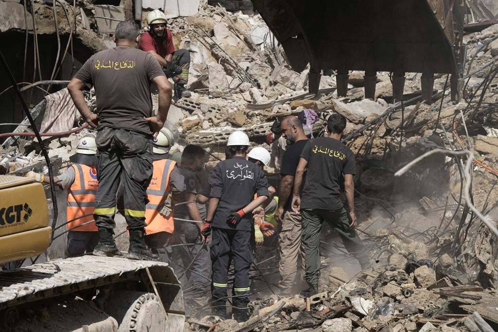 Emergency workers clear the rubble at the site of Friday's Israeli strike in Beirut's southern suburbs, Saturday, Sept. 21, 2024.