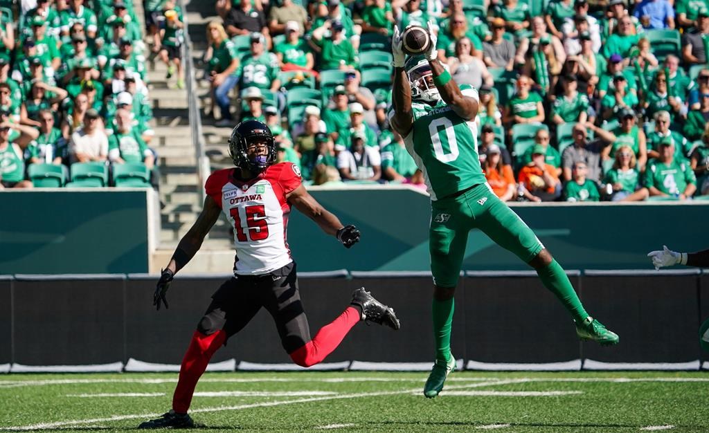 Saskatchewan Roughriders defensive back Rolan Milligan Jr. (0) intercepts a pass intended to Ottawa Redblacks receiver Dominique Rhymes (15) during the first half of CFL football action in Regina, on Saturday, September 28, 2024.