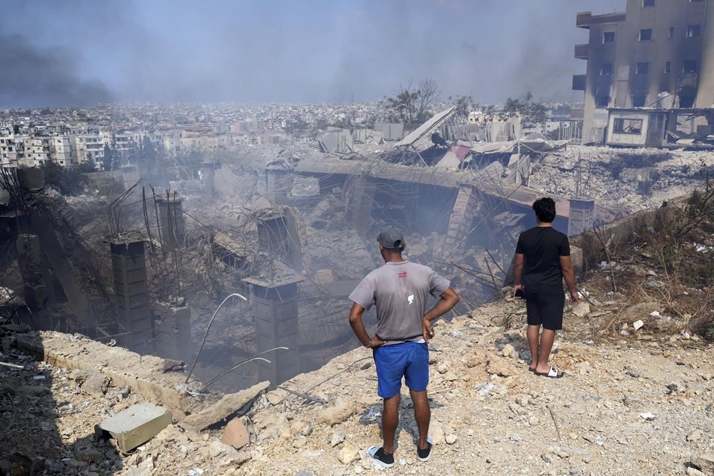 People check a damaged building at the site of an Israeli airstrike in Choueifat, south east of Beirut, Saturday, Sept. 28, 2024.