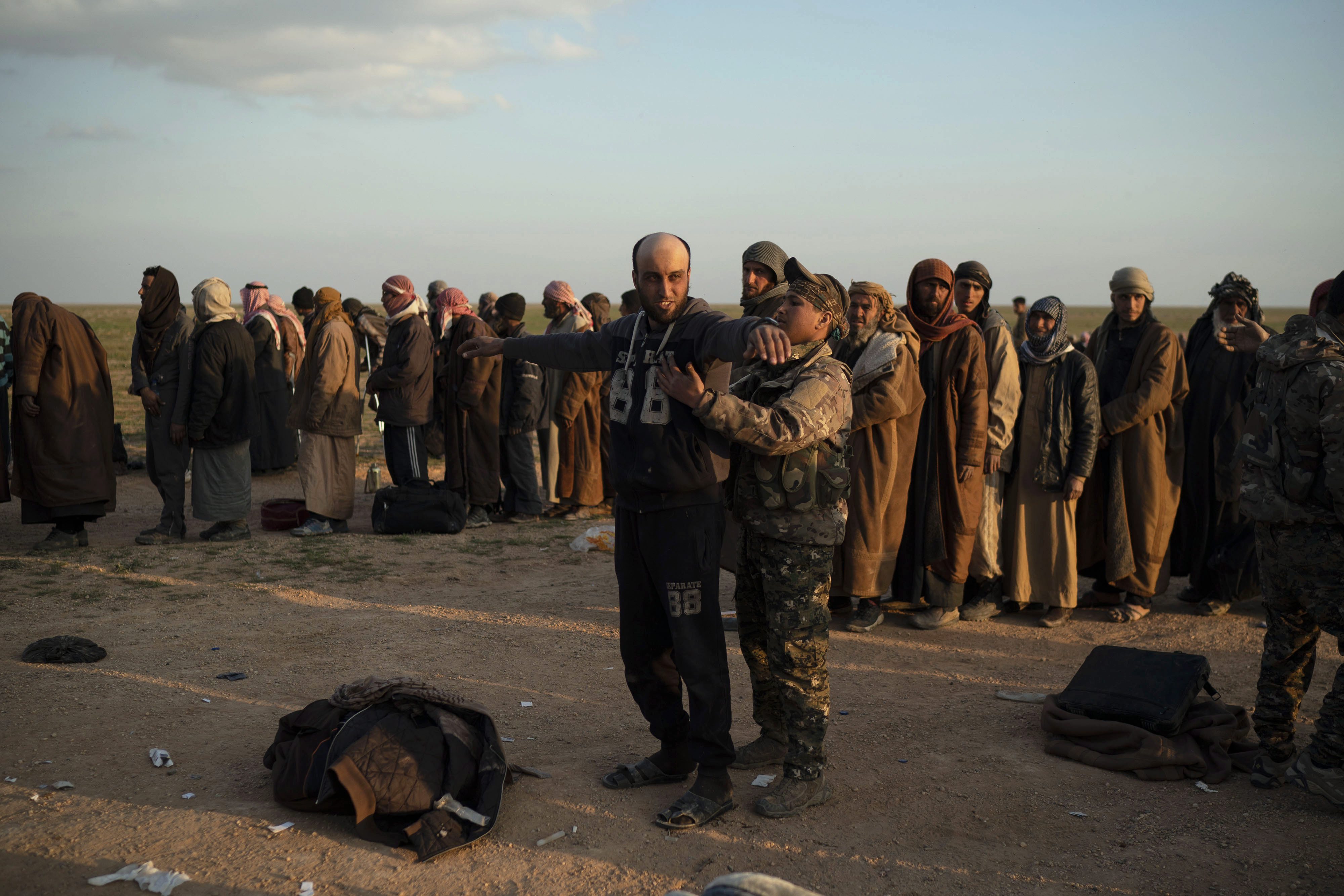 A U.S.-backed Syrian Democratic Forces fighter frisks a man evacuated from the last ISIS territory, Baghouz, Syria, on Feb. 22, 2019 (AP Photo/Felipe Dana, File)