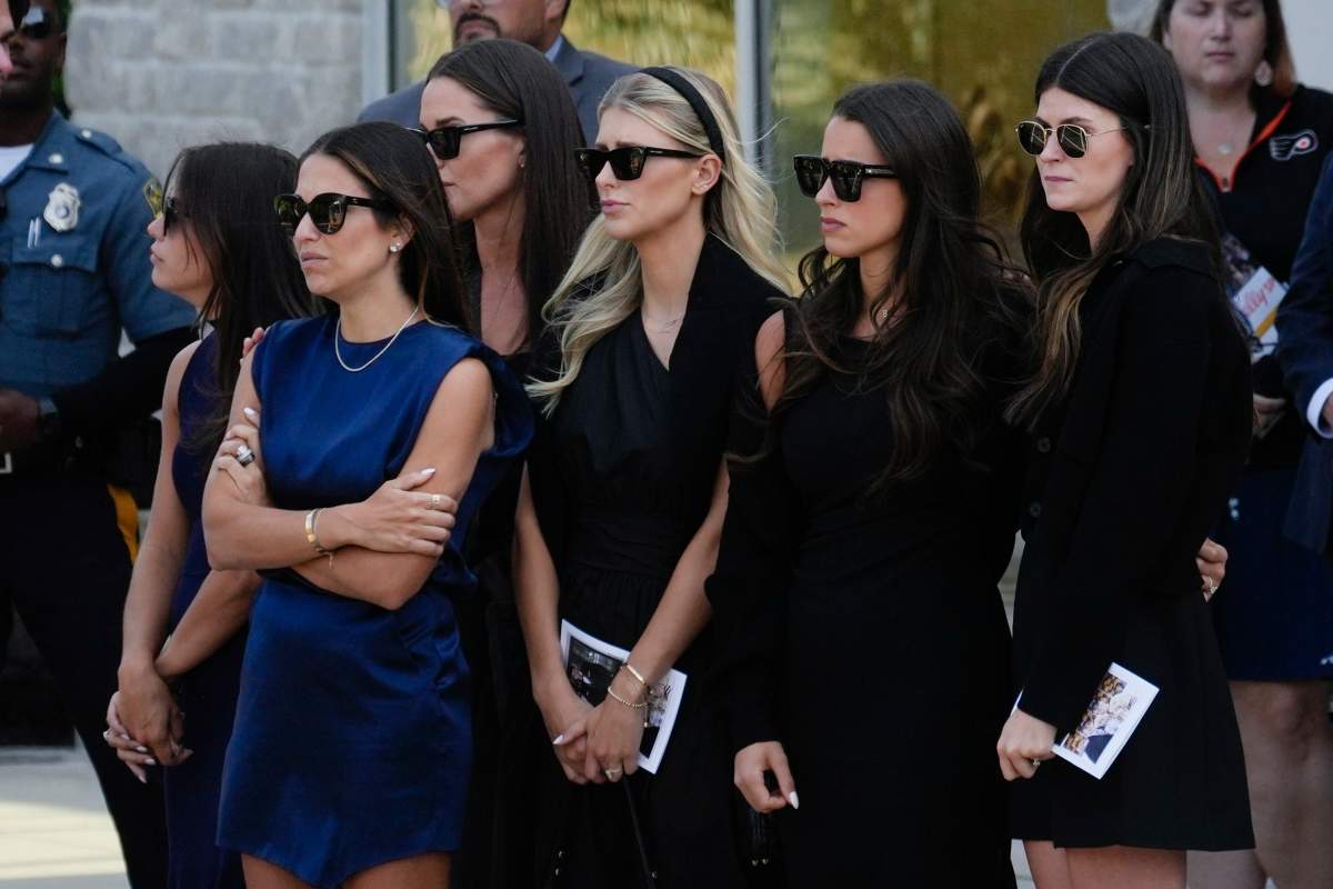 Mourners including, Meredith Gaudreau, second from left in blue, watch as the remains of Columbus Blue Jackets hockey player John Gaudreau and his brother Matthew Gaudreau depart following their funeral at St. Mary Magdalen Catholic Church in Media, Pa., Monday, Sept. 9, 2024.